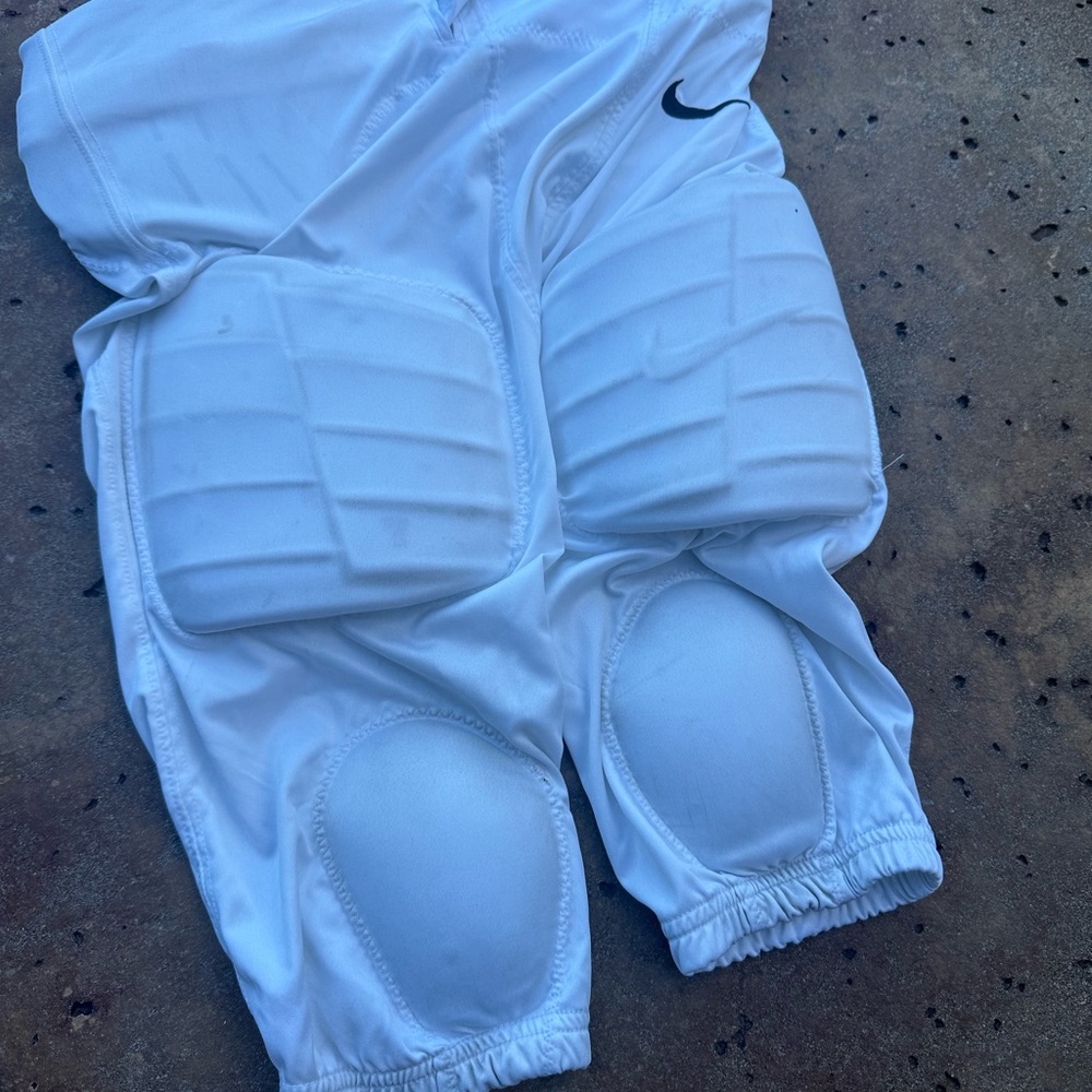 Nike dri-fit authentic size medium football pants with pads and belt.